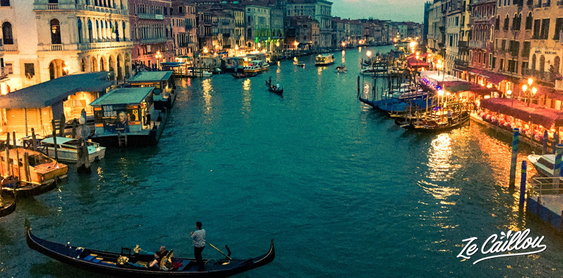 Visiter Venise en passant par le pont Rialto à la tombée de la nuit.