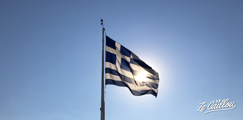 Drapeau grec qui vole au soleil à l'acropole à Athènes.