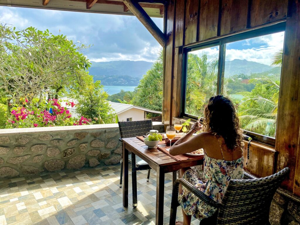 Déjeuner sur la petite terrasse vue mer vers Anse Soleil à Mahé lors d'un voyage aux Seychelles.