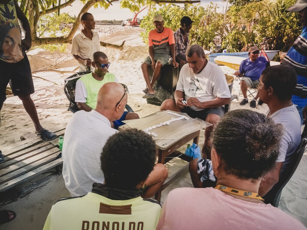 Observe the locals playing dominoes in the center of La Digue towards Anse La Réunion.
