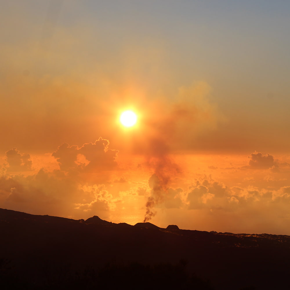 Coucher de soleil sur un cratère du volcan encore fumant.